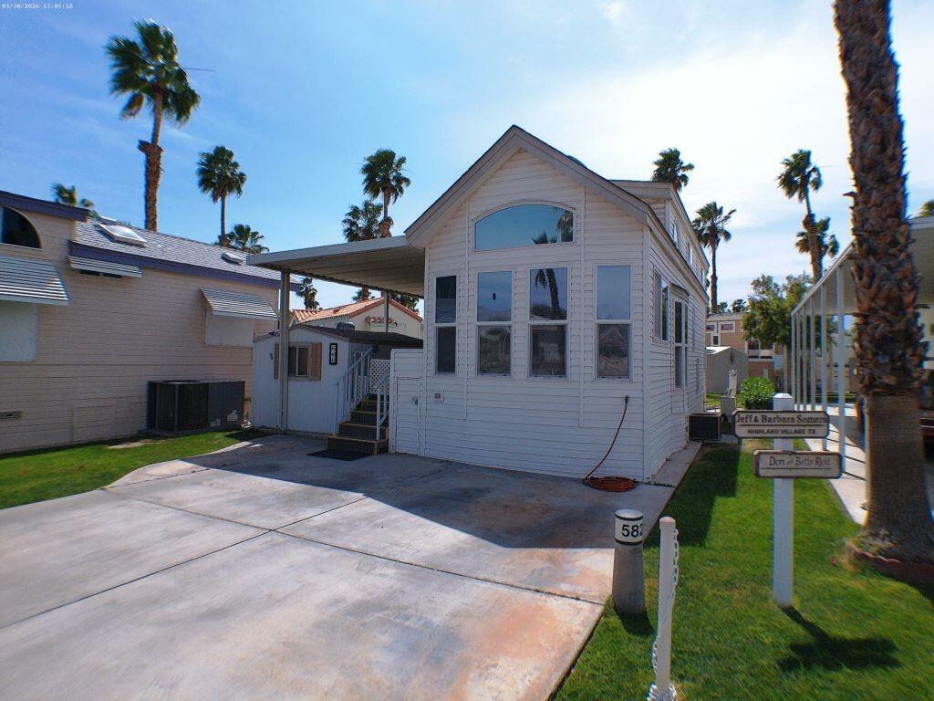 84136 Ave 44, Unit 582 Indio, CA 92203 - Photo 3 of 56 a front view of a house with a yard and garage
