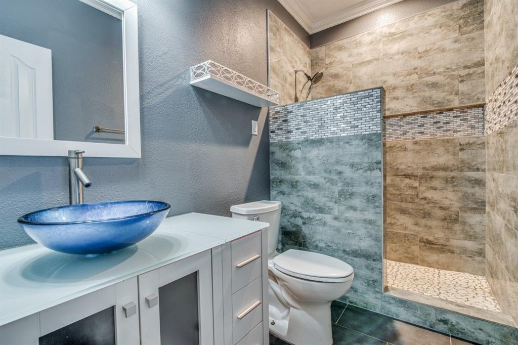3814 Ridgecrest Avenue Rowlett, TX 75088 - Photo 15 of 24 a bathroom with a granite countertop toilet a sink and a mirror