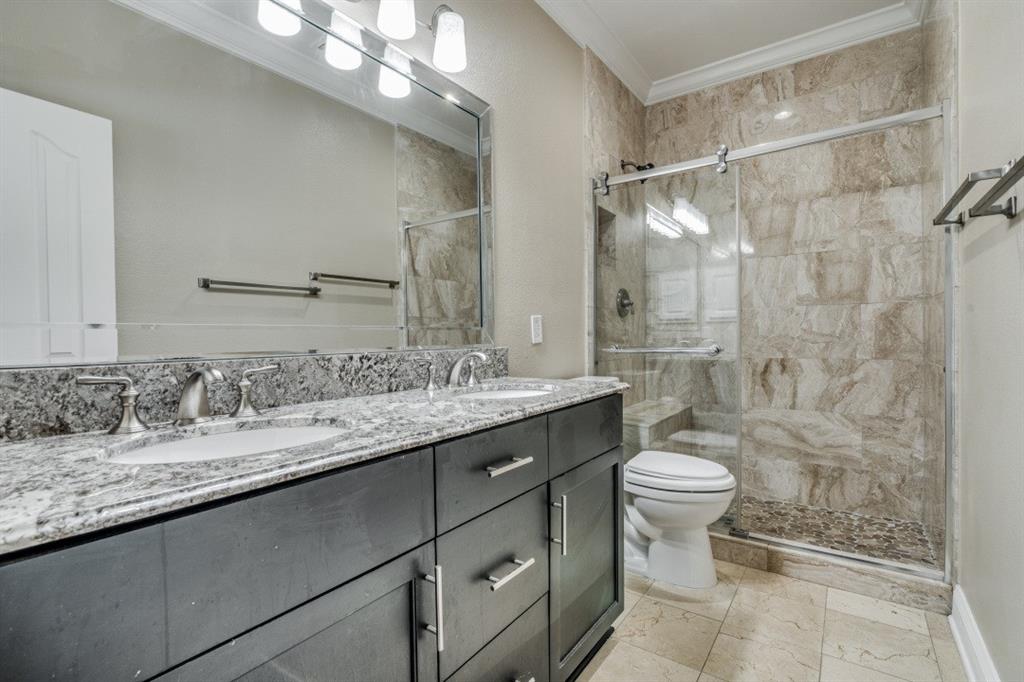 3814 Ridgecrest Avenue Rowlett, TX 75088 - Photo 19 of 24 a bathroom with a granite countertop sink a toilet a mirror and shower