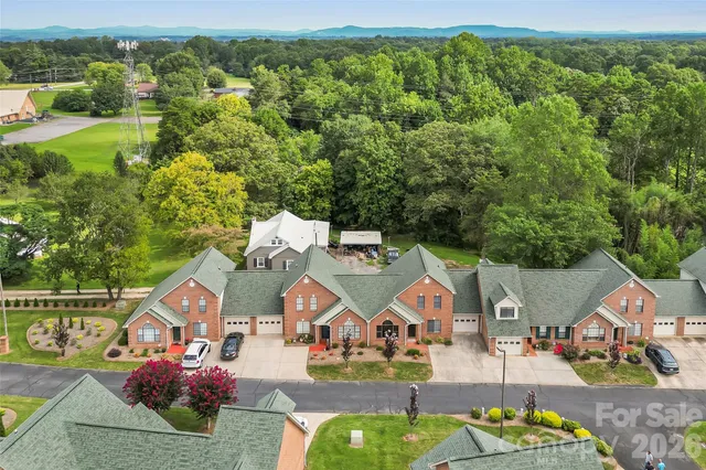 an aerial view of residential houses with outdoor space and trees
