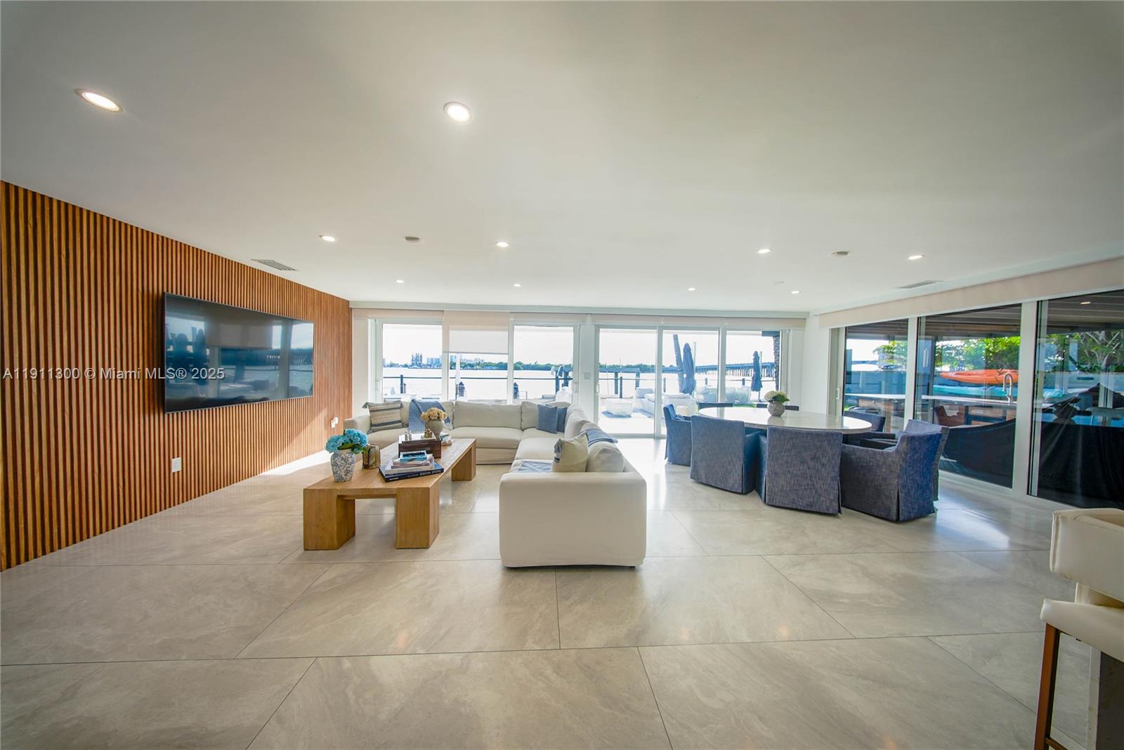 1242 Northeast 81st Terrace Miami, FL 33138 - Photo 5 of 23 a living room with furniture a flat screen tv and floor to ceiling window