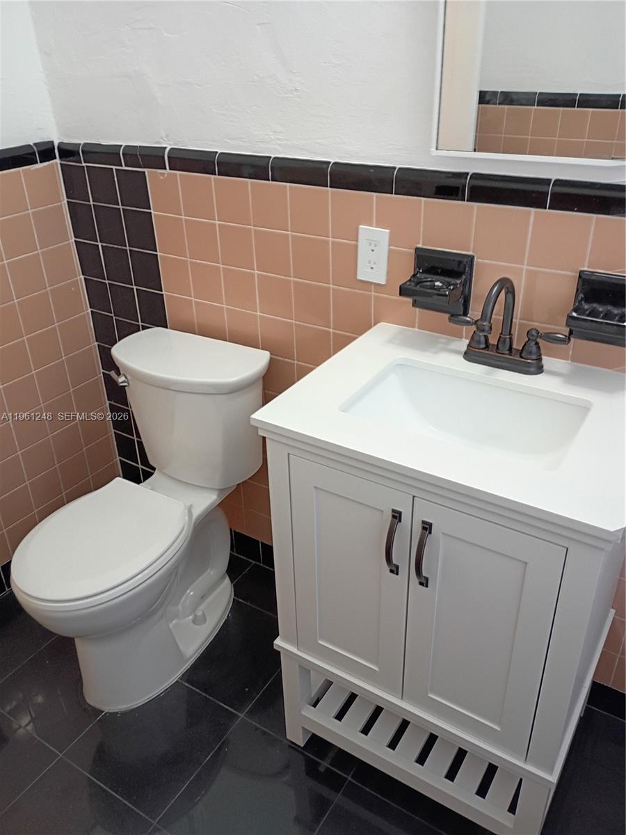 235 83rd Street, Unit 3 Miami Beach, FL 33141 - Photo 18 of 27 a bathroom with a sink a toilet and a mirror