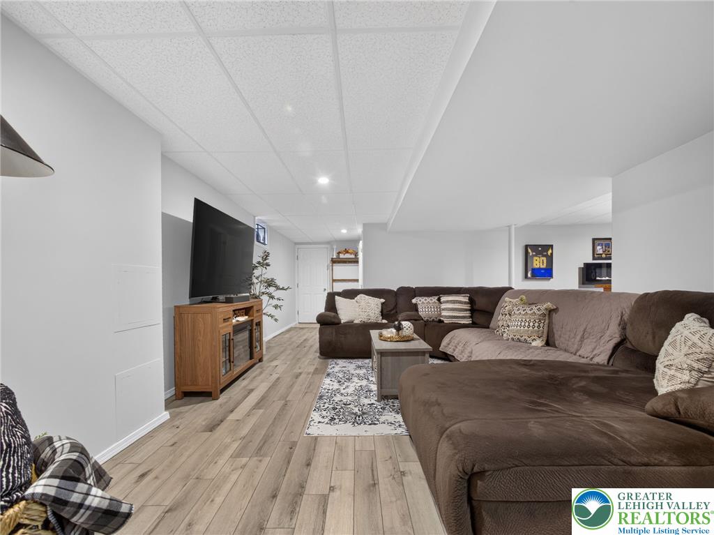 4148 Ross Road Bethlehem, PA 18020 - Photo 64 of 67 Well-lit and inviting, this recreation room features light-toned flooring and a spacious sectional, perfect for relaxation.