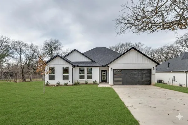 a front view of a house with a garden and yard