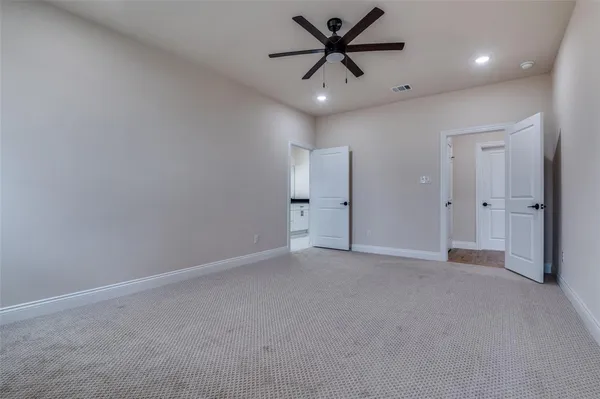 an empty room with closet and a ceiling fan