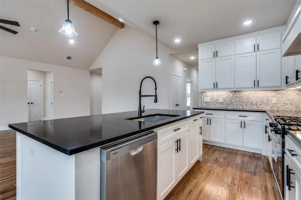 a kitchen with granite countertop a sink and cabinets