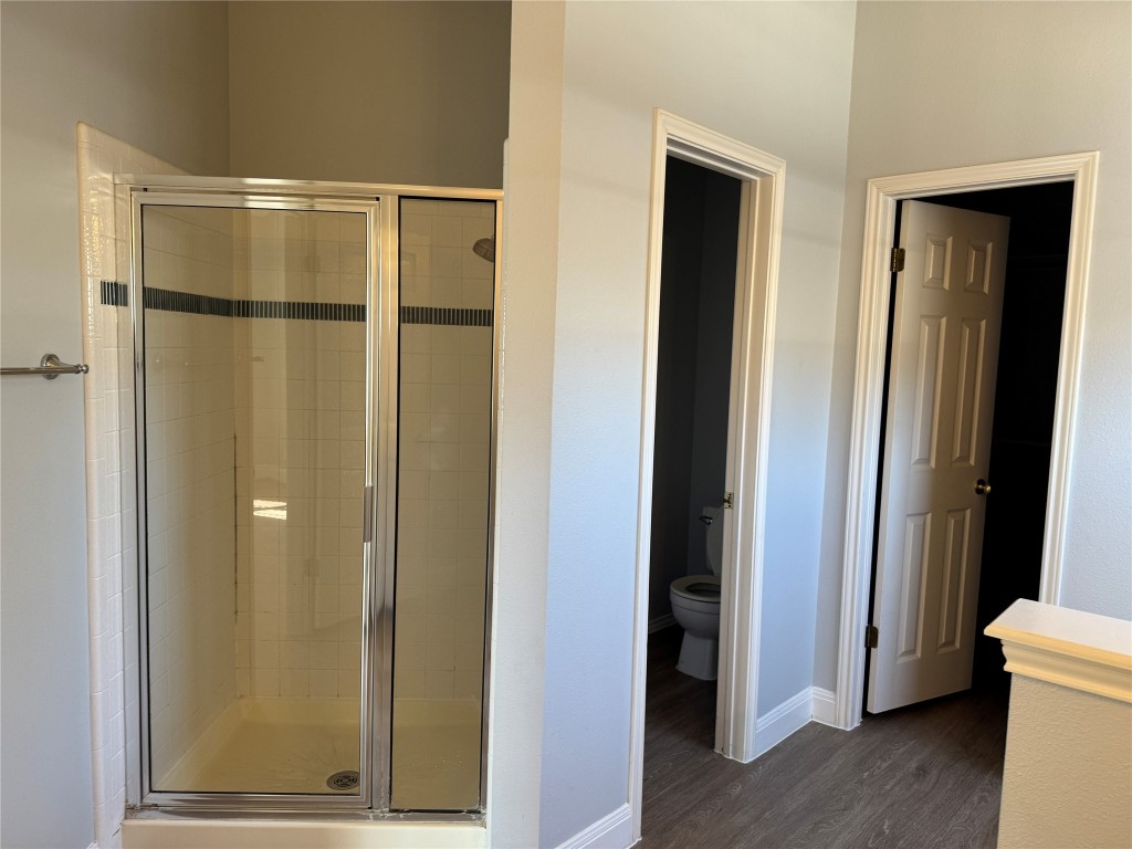 12714 Tantara Drive Austin, TX 78729 - Photo 14 of 25 Bathroom featuring a shower stall and dark wood finished floors