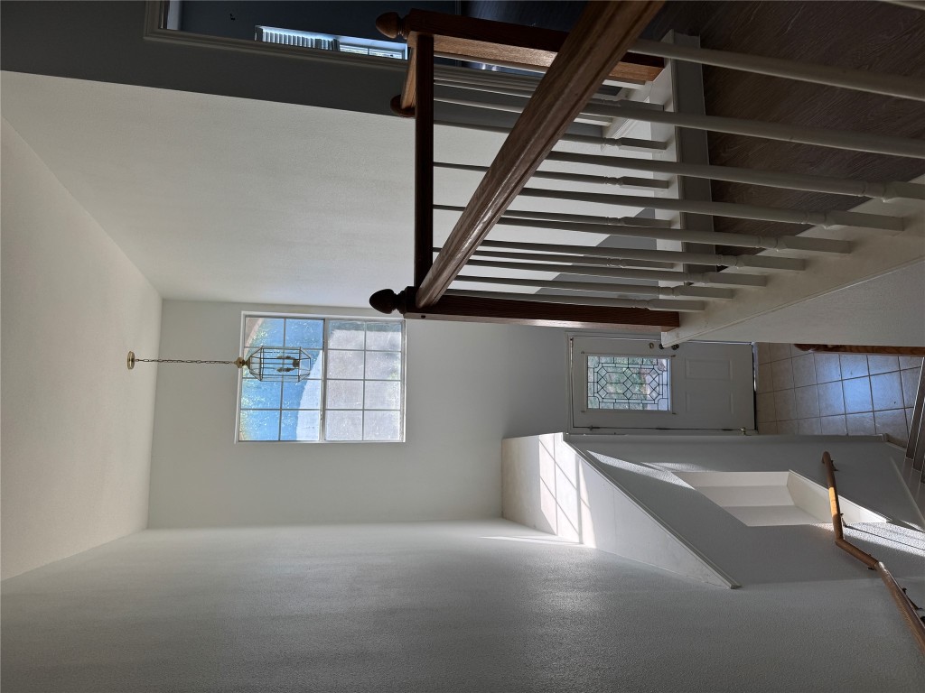 12714 Tantara Drive Austin, TX 78729 - Photo 18 of 25 Stairs featuring tile patterned floors, a towering ceiling, and a chandelier