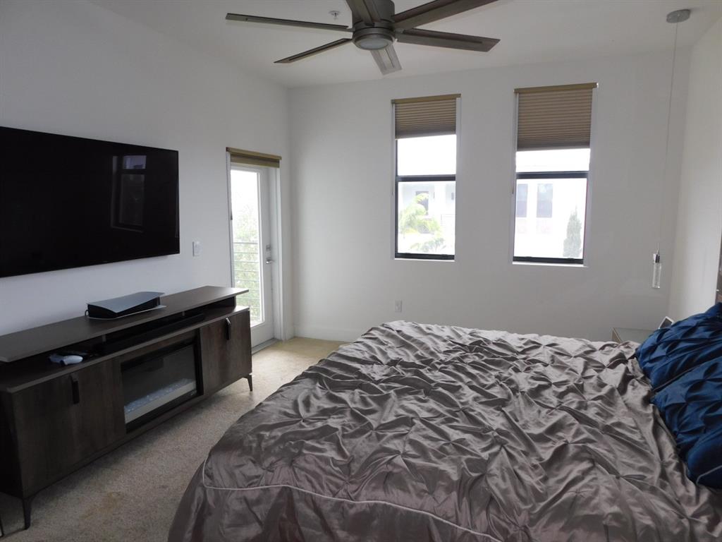 4381 Northwest 9th Street, Unit 4381 Plantation, FL 33317 - Photo 21 of 46 a bedroom with a bed and a flat screen tv