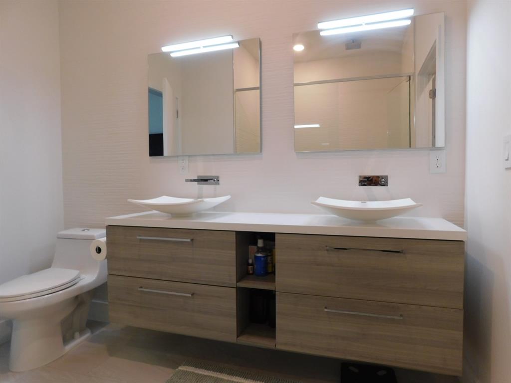 4381 Northwest 9th Street, Unit 4381 Plantation, FL 33317 - Photo 25 of 46 a bathroom with a sink a toilet and mirror
