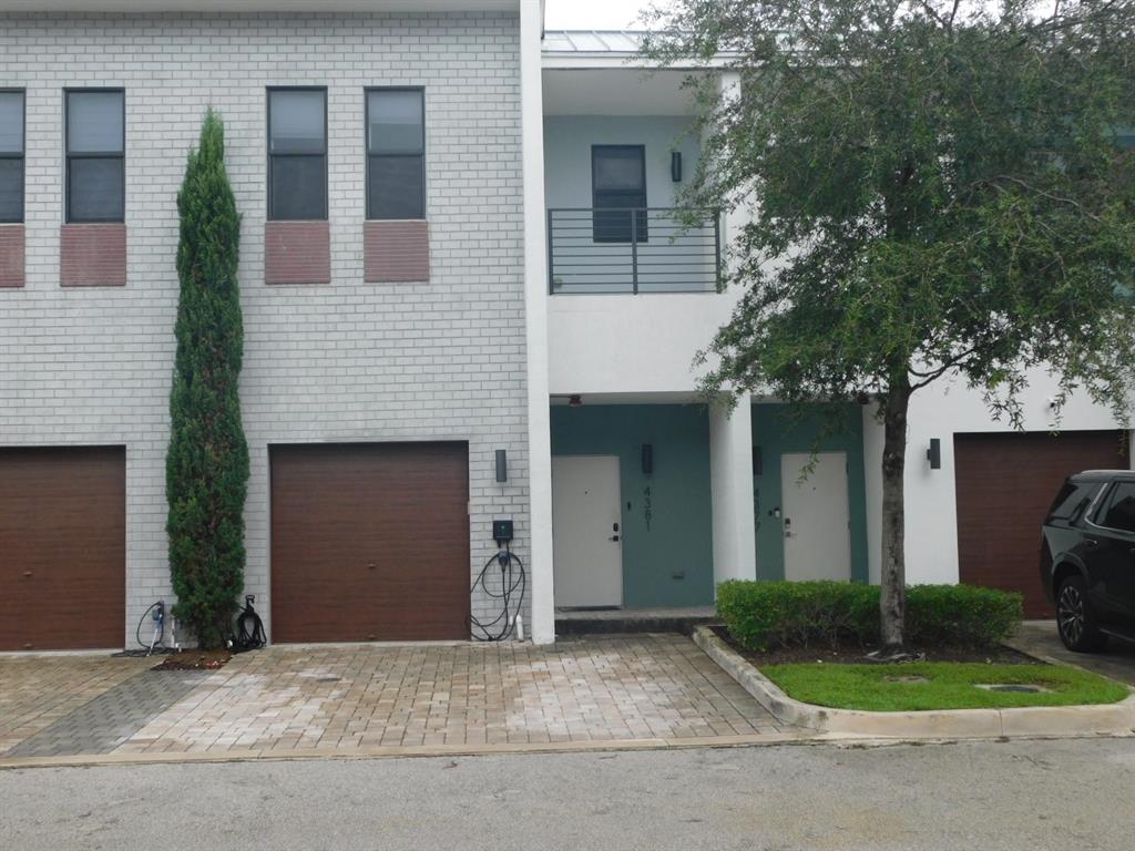 4381 Northwest 9th Street, Unit 4381 Plantation, FL 33317 - Photo 38 of 46 a front view of a house with a yard and garage