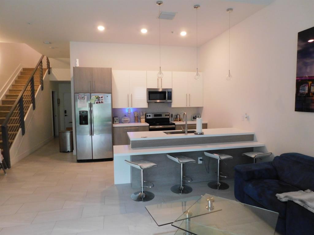 4381 Northwest 9th Street, Unit 4381 Plantation, FL 33317 - Photo 5 of 46 a kitchen with stainless steel appliances a refrigerator and a stove top oven