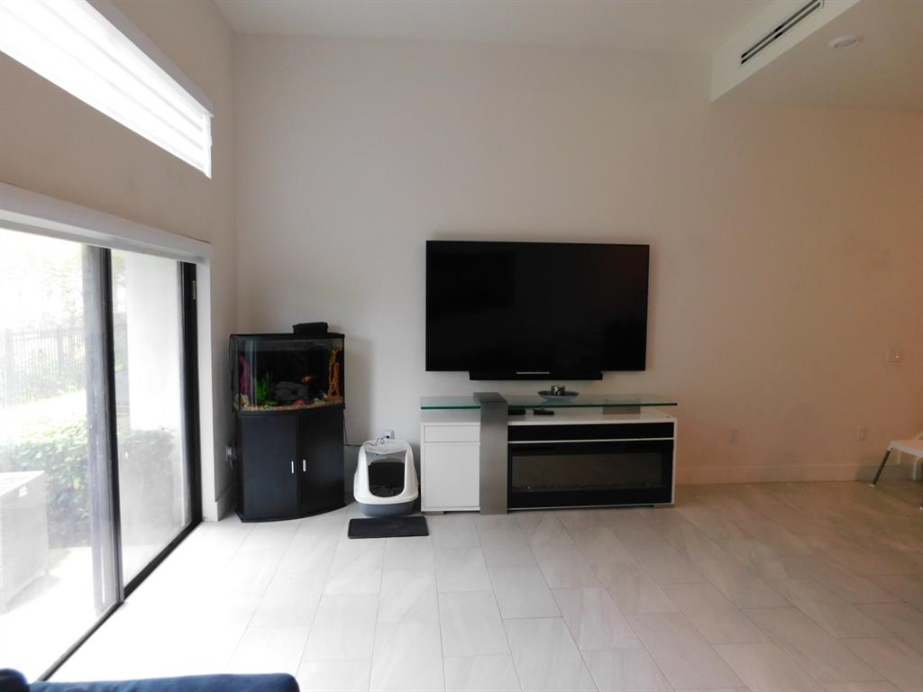 4381 Northwest 9th Street, Unit 4381 Plantation, FL 33317 - Photo 9 of 46 a living room with a flat screen tv and refrigerator