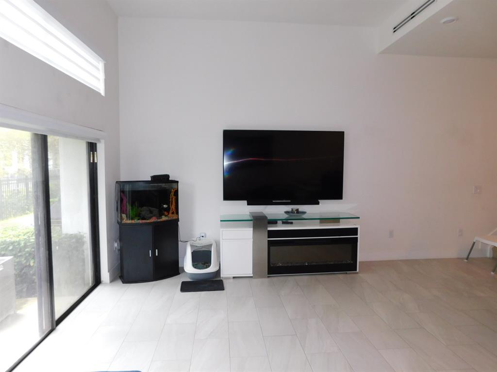 4381 Northwest 9th Street, Unit 4381 Plantation, FL 33317 - Photo 10 of 46 a living room with a flat screen tv and refrigerator