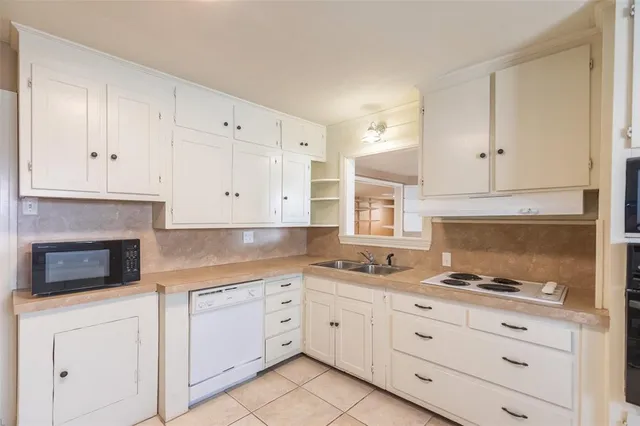 a kitchen with granite countertop white cabinets and white appliances