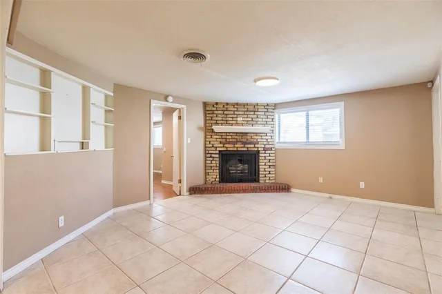 a view of an empty room with a fireplace and a window