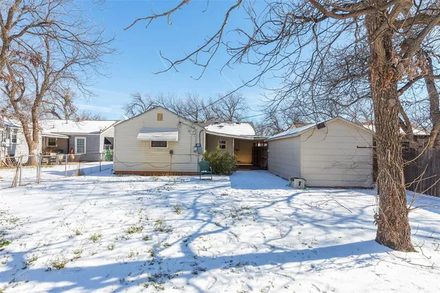 a view of a house with a yard covered in snow