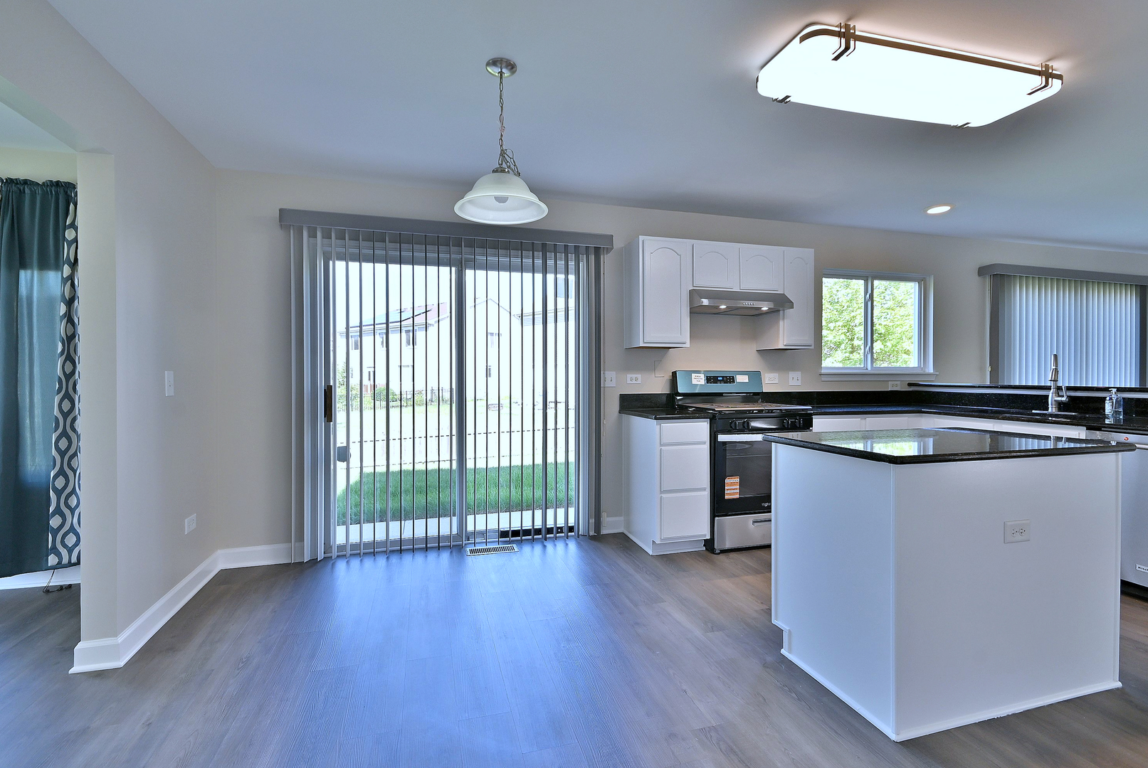 2434 White Barn Road Aurora, IL 60502 - Photo 18 of 45 a kitchen with stainless steel appliances granite countertop wooden floors and white cabinets
