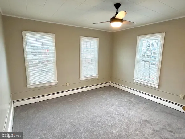 an empty room with windows and closet