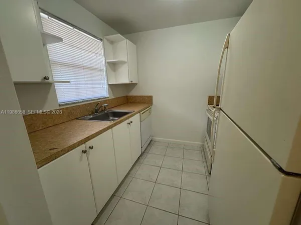 a kitchen with a sink a stove and a refrigerator