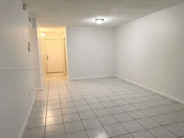 en empty room with white walls and tiles