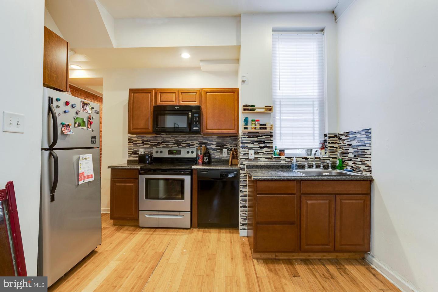 4031 Green Street, Unit A Philadelphia, PA 19104 - Photo 3 of 12 a kitchen with stainless steel appliances a refrigerator and a stove top oven