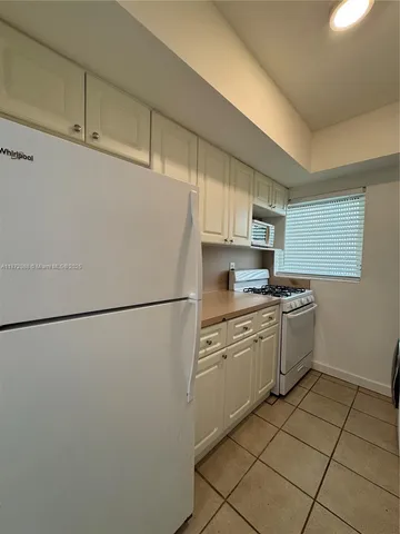 a kitchen with a refrigerator sink and cabinets