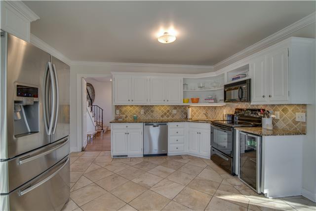 4215 Sneed Road Nashville, TN 37215 - Photo 7 of 20 a kitchen with granite countertop a refrigerator and a stove top oven