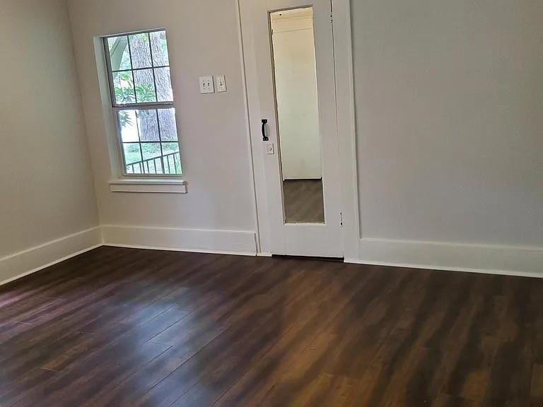 304 Fulton Street, Unit B Denton, TX 76201 - Photo 4 of 10 Unfurnished bedroom with baseboards and dark wood finished floors