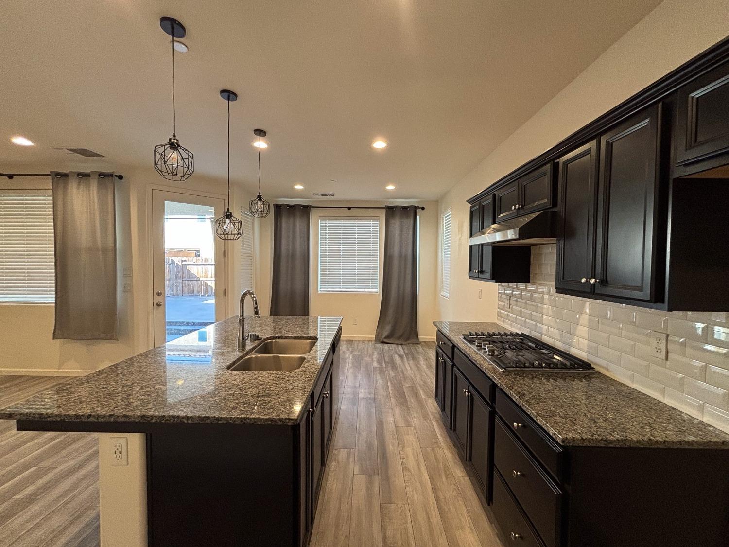 827 Fir Street West Madera, CA 93636 - Photo 12 of 63 a kitchen with stainless steel appliances granite countertop a sink stove and refrigerator