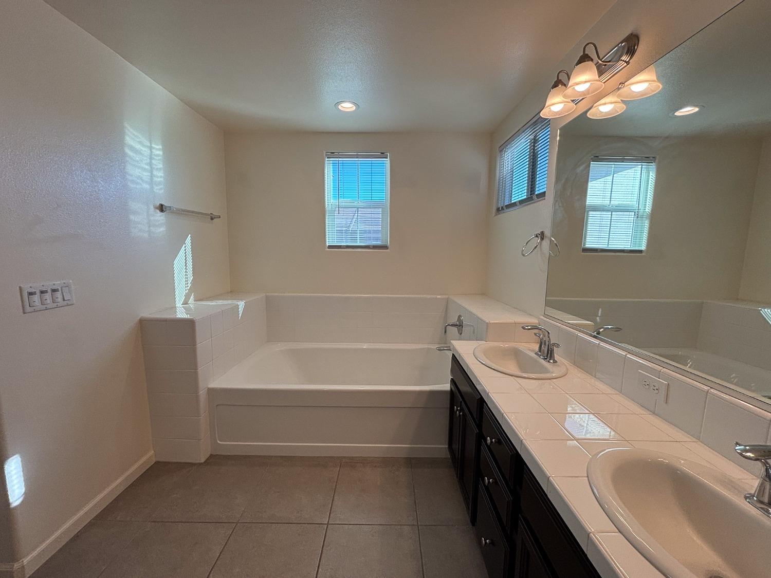 827 Fir Street West Madera, CA 93636 - Photo 40 of 63 a bathroom with a sink double vanity granite tub and a mirror