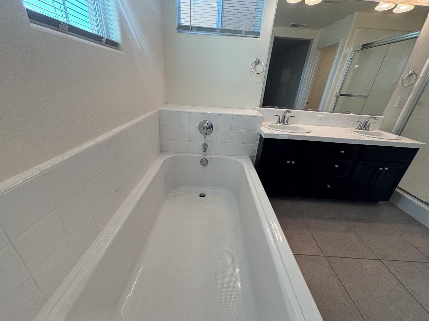 827 Fir Street West Madera, CA 93636 - Photo 42 of 63 a spacious bathroom with a tub sink and mirror