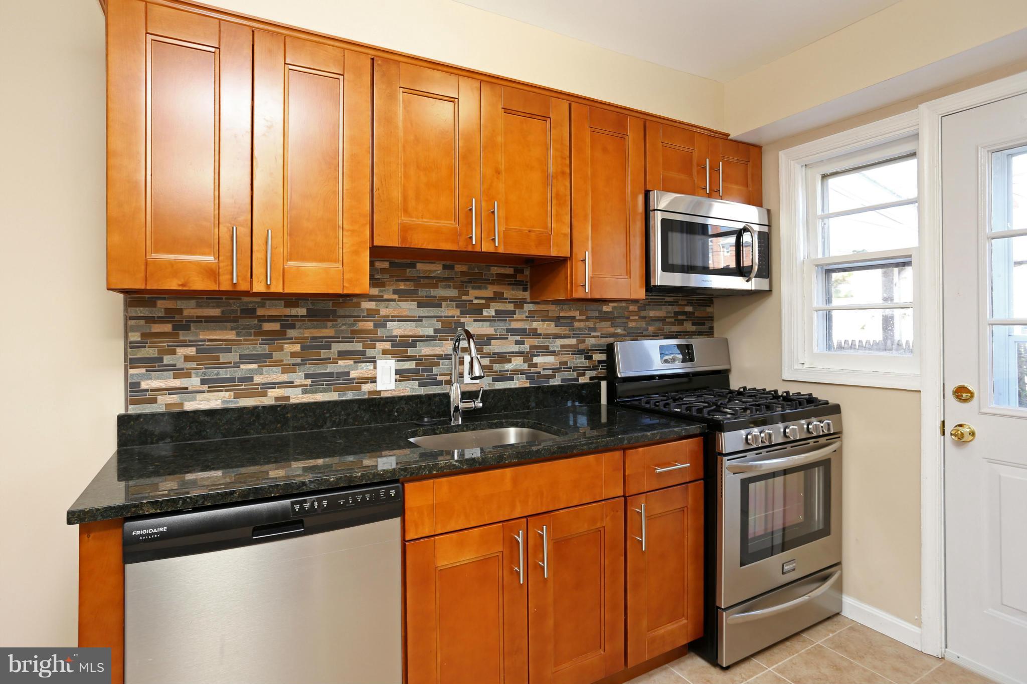 4440 Fenor Road Baltimore, MD 21227 - Photo 9 of 30 a kitchen with granite countertop wooden cabinets and a stove top oven