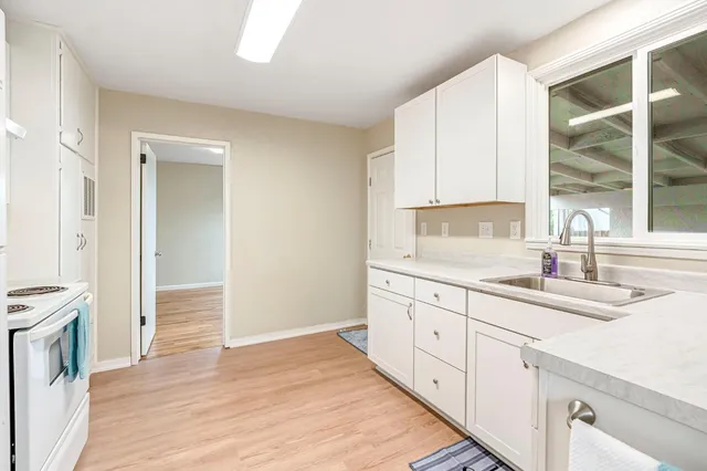 a kitchen with granite countertop white cabinets and white appliances
