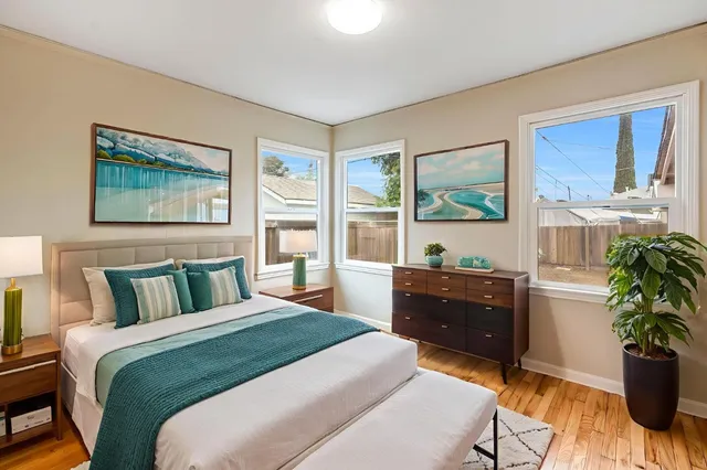 a bedroom with a bed and a dresser next to a window