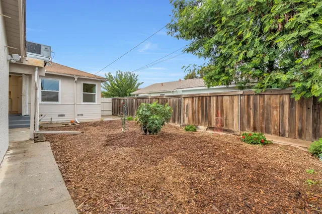 a backyard of a house with plants and trees