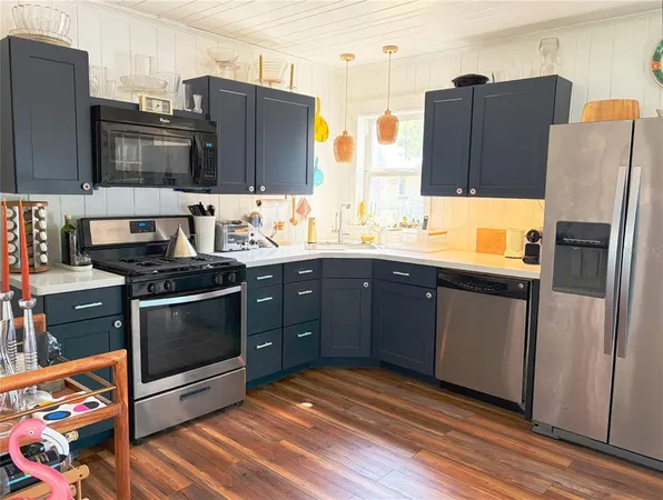 a kitchen with stainless steel appliances granite countertop a refrigerator and a stove top oven