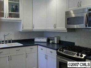 440 Westbury Road Charlotte, NC 28211 - Photo 6 of 8 a kitchen with granite countertop white cabinets and black stove top oven