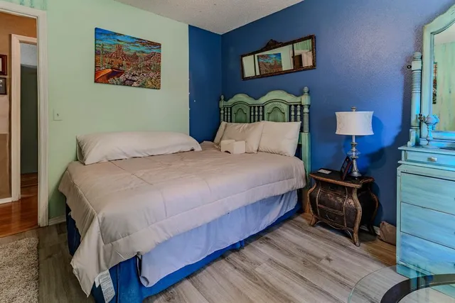 a bedroom with a bed and wooden floor