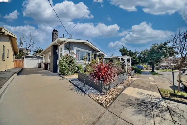 a kitchen with stainless steel appliances kitchen island granite countertop a refrigerator a sink a stove and white cabinets with wooden floor