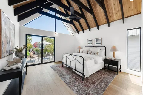 a white bed sitting in a room next to a window