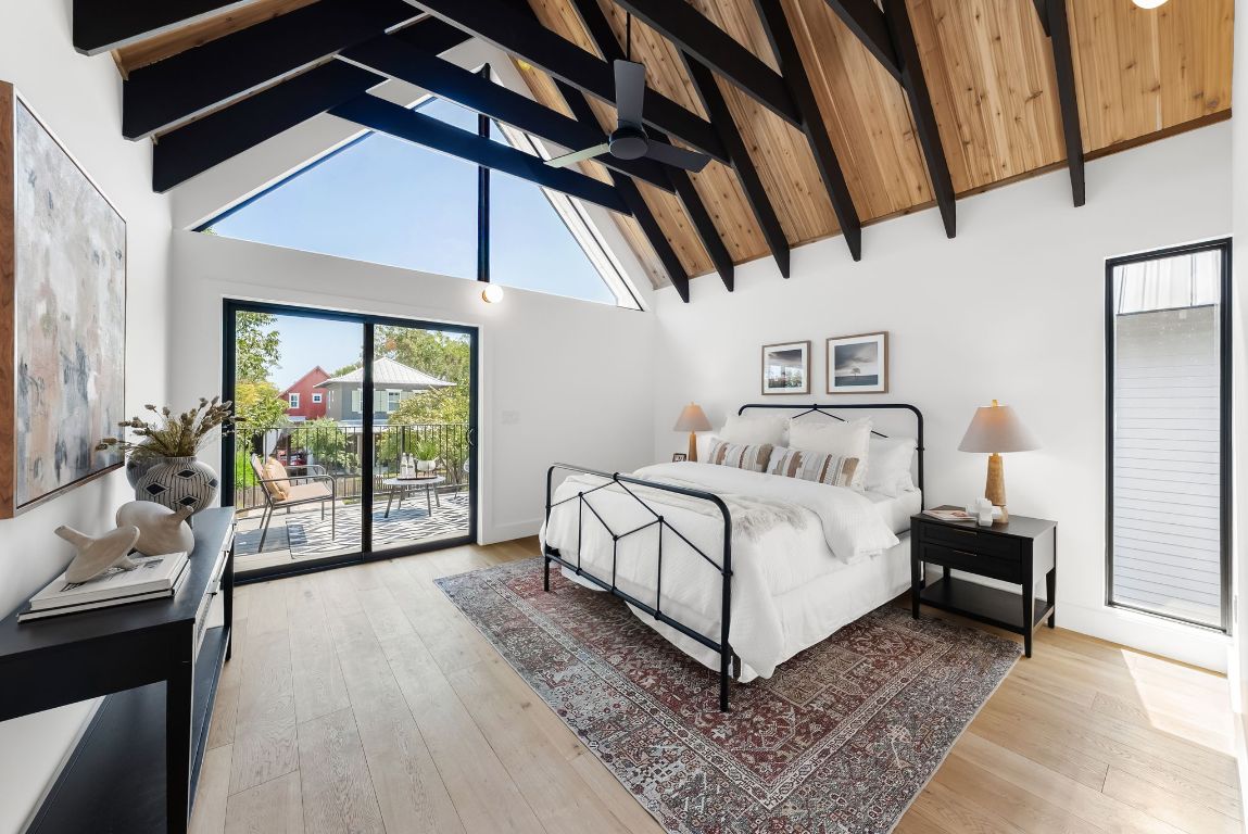 a white bed sitting in a room next to a window