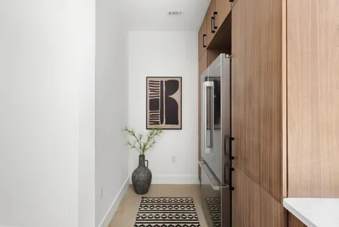 a view of a hallway with a potted plant and wooden floor