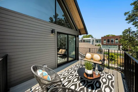 a balcony with wooden floor and outdoor seating