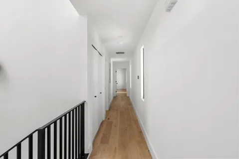 a view of a hallway with wooden floor