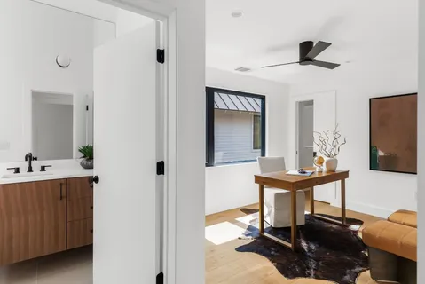 a view of a workspace room with wooden floor cabinet and mirror