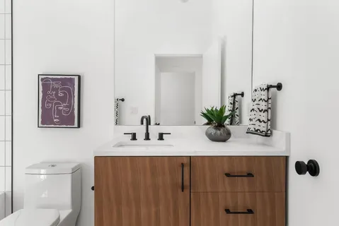 a bathroom with a granite countertop sink a toilet and mirror
