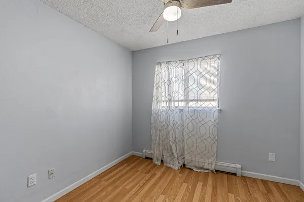 a view of a room with wooden floor and a fan