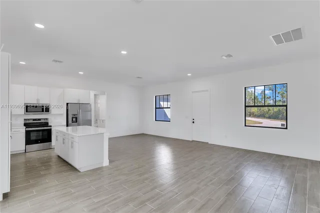 a large kitchen with white cabinets and stainless steel appliances