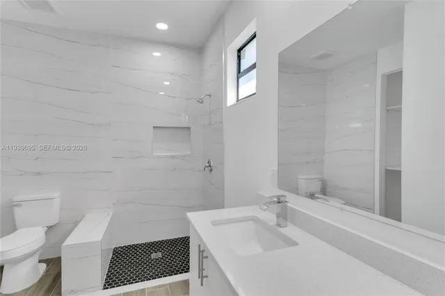 an empty room with wooden floor ceiling fan and windows